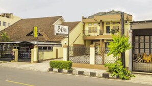 A hotel with a signboard, a gated entrance, and a well-maintained lawn. - SPOT ON 2395 Hotel Aden 2 Syariah (Tasikmalaya)