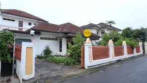 A residential area with houses, a gated entrance, and a 'SPOT ON' sign. - OYO 2268 Tim-tim Homestay SyariahNearUniversitas Gadjah Mada (Depok)