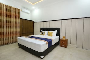 Un dormitorio ordenado con cama, mesita de noche y armario.
