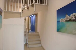 A staircase leading to a second floor with a view of a coastal cityscape. - New modern seafront studio apartment in Marsascala (Marsaskala)