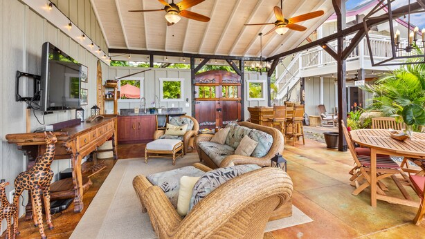 A covered outdoor living area with wicker furniture, ceiling fans, and a dining table. - The “Promise Tree” is a great family  gathering place in Kailua Kona! (Kailua-Kona)