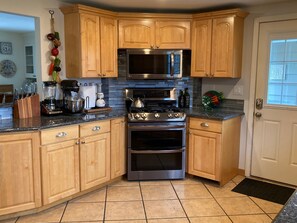 Enjoy cooking in this well-equipped kitchen with a stainless steel stove, sink, and various appliances.
