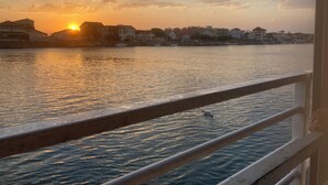 A sunset over a body of water with buildings in the background.
