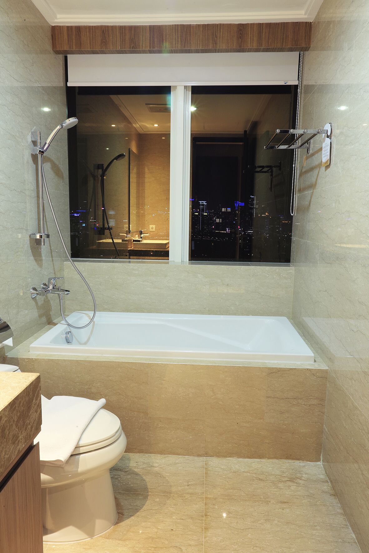 Een moderne badkamer met een bad, douche en toilet.
