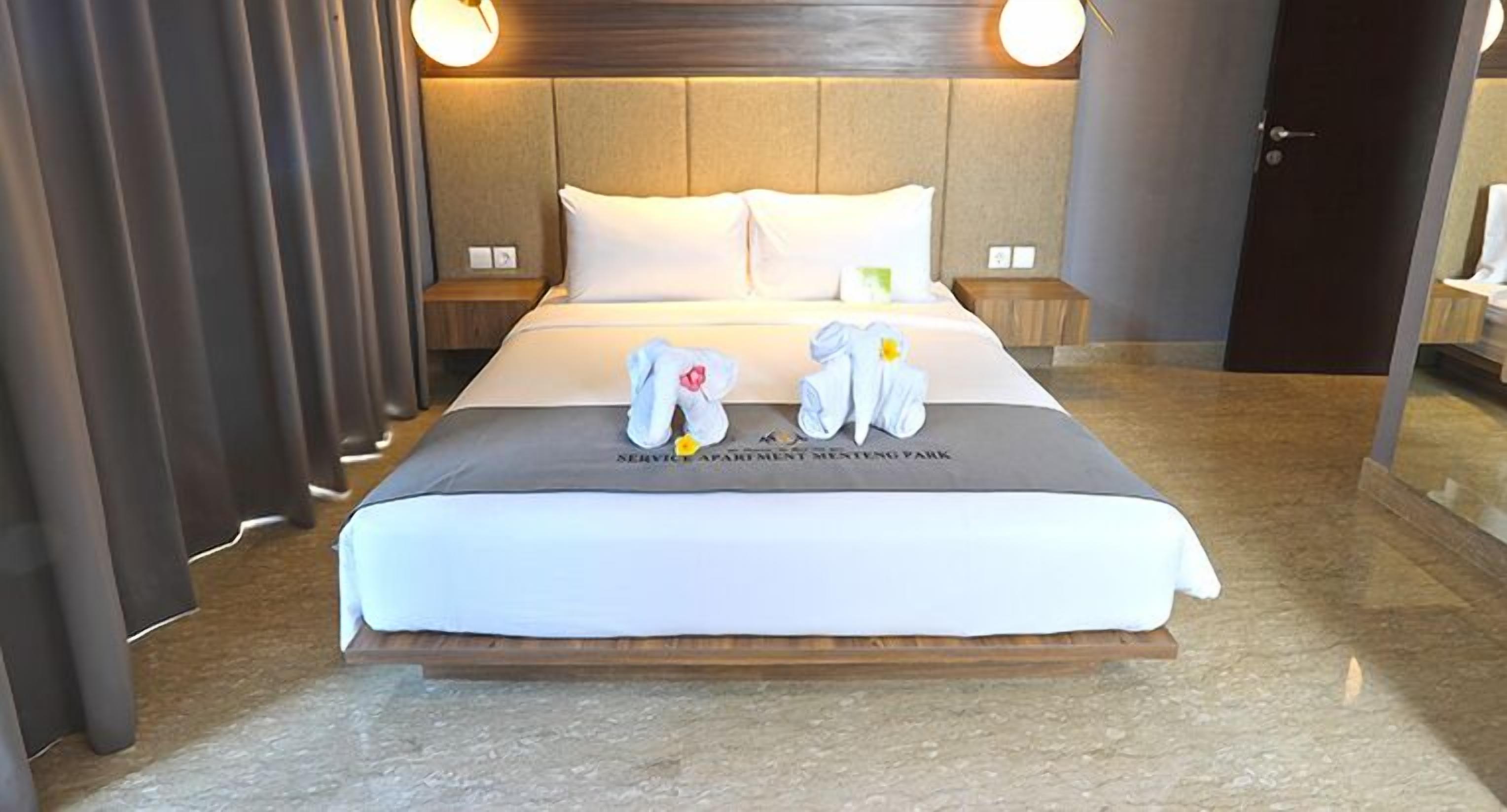 A hotel room with a bed, two bedside tables, and a nightstand.