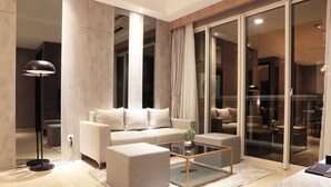 Una sala moderna con sofá, reposapiés y mesa de centro.