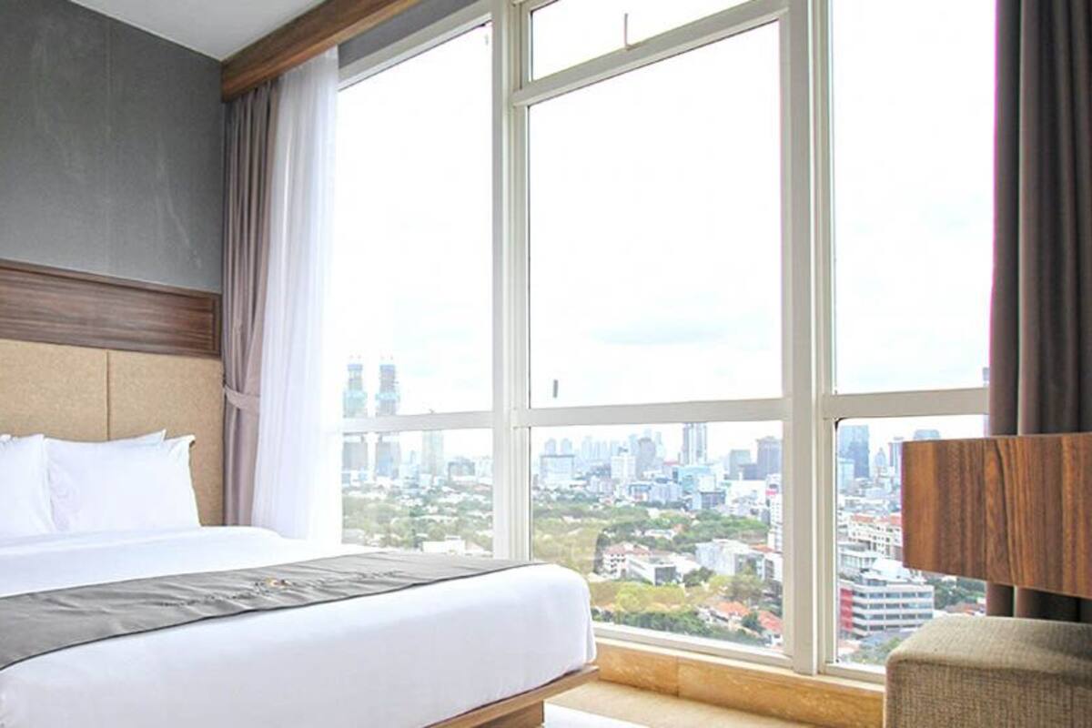 Ein Hotelzimmer mit einem großen Bett, Blick auf die Stadt und modernem Design.