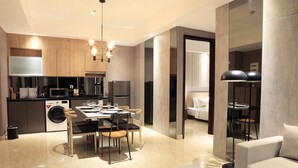 Una cocina moderna con comedor, lavadora y sofá en un espacio habitable contemporáneo.