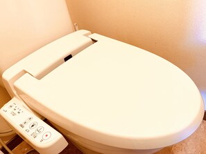 A toilet with a control panel featuring multiple buttons and a flush handle. - Paragon Residence OSAKA (Osaka)