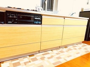 A kitchen with wooden cabinets, a built-in oven, and a microwave.