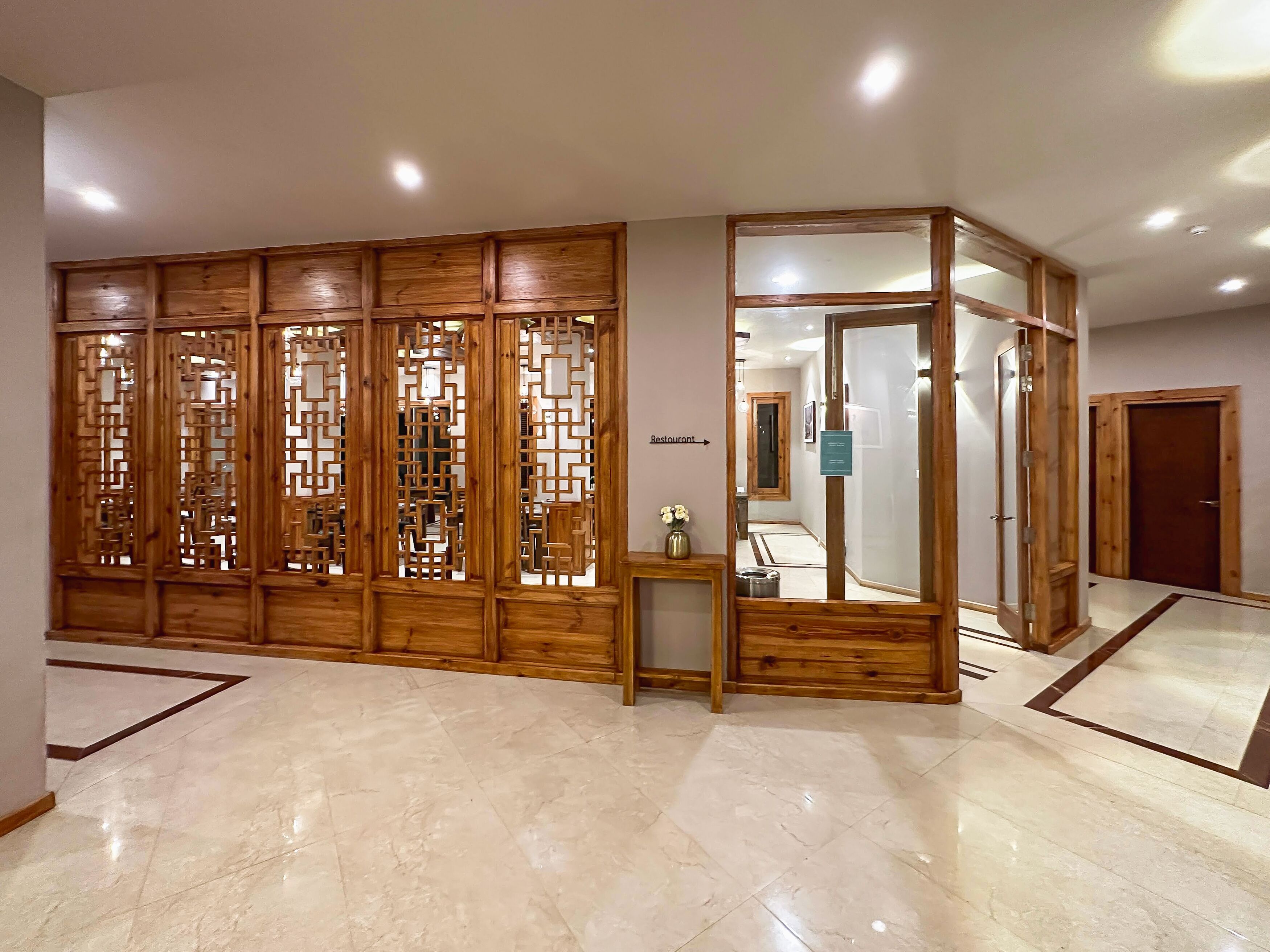 A hallway with a wooden partition and a mirror.