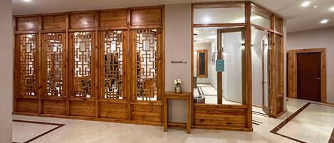 A hallway with a wooden partition and a mirror.