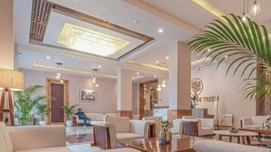 A modern hotel lobby with a central seating area, a reception desk, and a large chandelier. - The Bodhi Tree Ladakh (Leh)