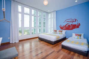 A hotel room with two beds, a large window, and a wall mural of a car.