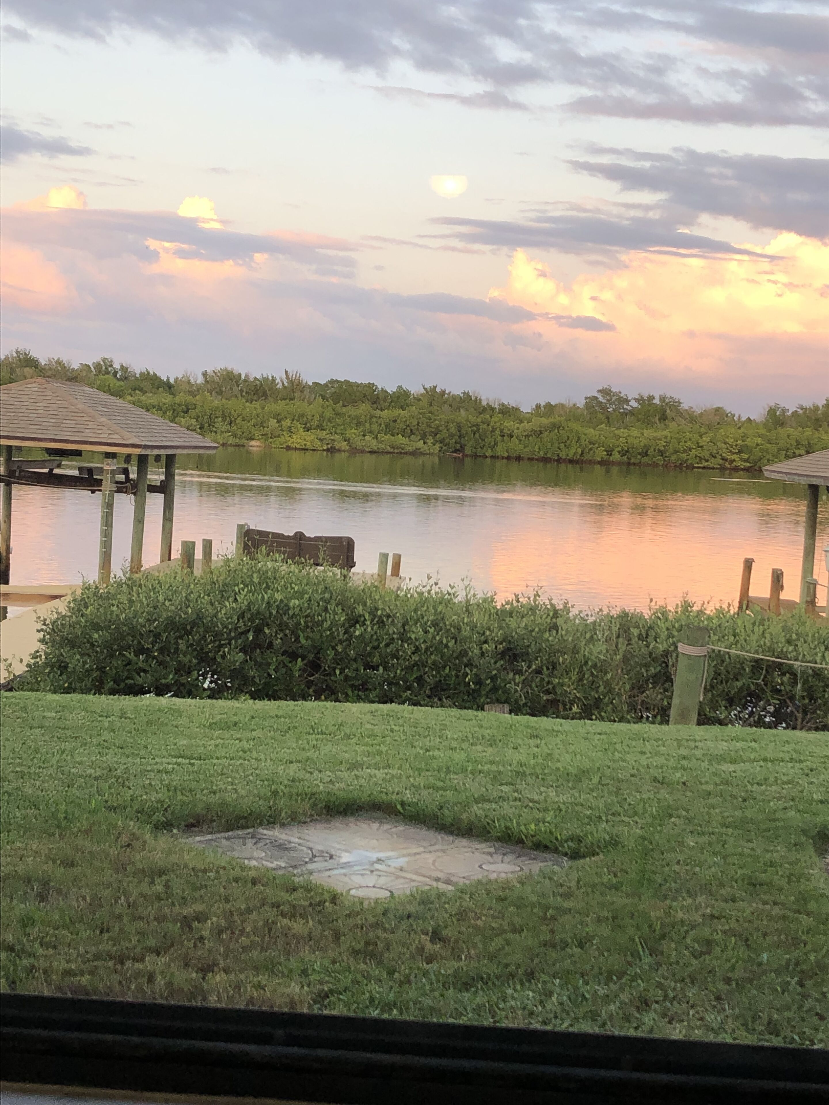A lakeside view with a gazebo, grassy area, and a dock.