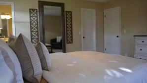 A bedroom with a large bed, a dresser, and a mirror. - "Water's Edge" Beautiful Waterfront Home In Edgewater, Florida (Edgewater)