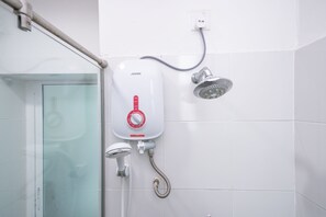 A shower with a control panel, a handheld showerhead, and a wall-mounted showerhead.