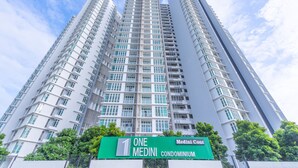 A high-rise building with multiple balconies and a green sign indicating it is a One Medini condominium. - OYO Home 89736 Unbelievable 2br 1medini (Iskandar Puteri)