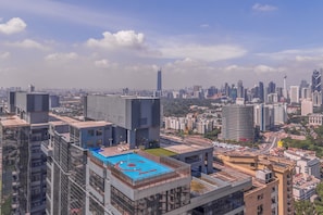A high-rise building with a rooftop pool and a view of the cityscape.