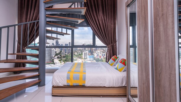 Ein modernes Schlafzimmer mit einem großen Bett, einer Holztreppe und Blick auf die Stadt.