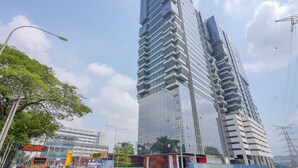 Ein modernes Hochhaus mit Glasfassade und einem strukturierten, kantigen Design.