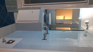 Un baño con ducha de vidrio, lavamanos blanco y espejo sobre él.