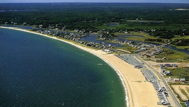 An aerial view of a coastal area with a beach, a road, and several buildings. - ** Labor day on 3day min. Beach 0.7 Mi walk- Craigville & Covell. A/C, bikes. (Barnstable)