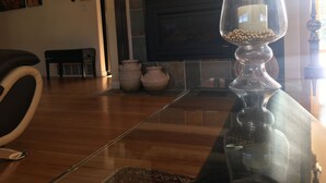 Un salón con chimenea, televisor y jarrones decorativos.