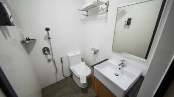 A modern bathroom with a white sink, mirror, and toilet.