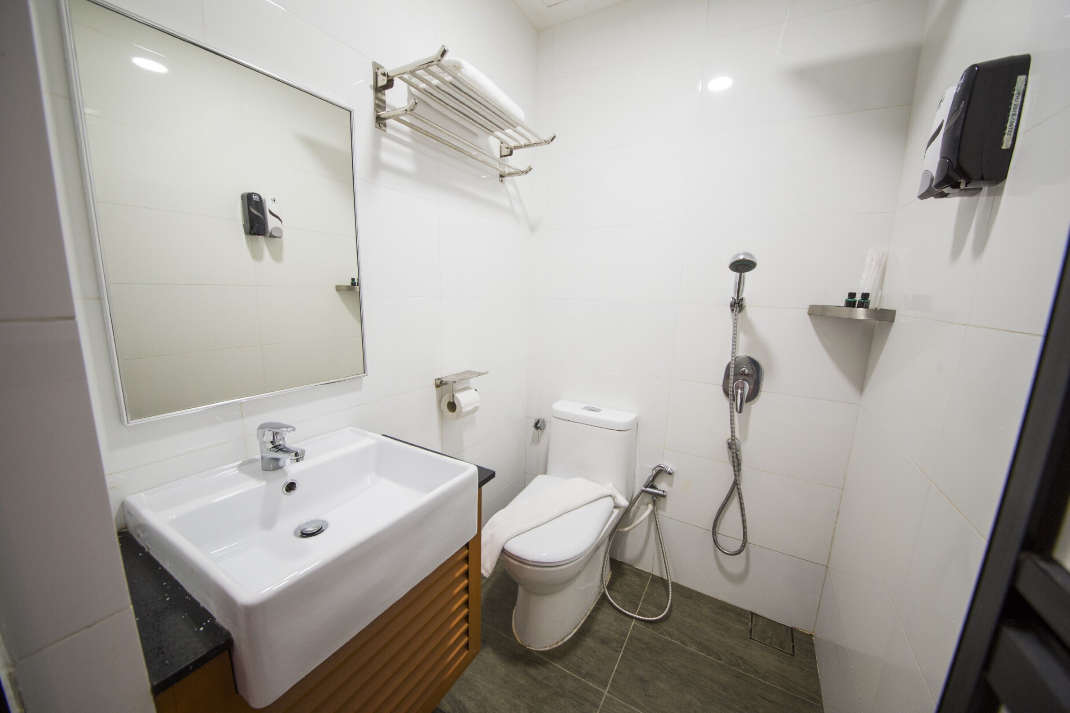 Ein modernes Badezimmer mit Waschbecken, Toilette und Dusche in Weiß.