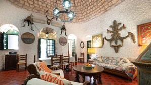 Una camera tradizionale con soffitto alto, arredamento rustico e zona pranzo.