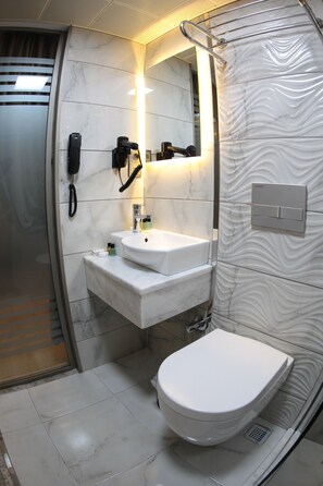 A modern bathroom with a white toilet, a sink, and a mirror. - X-Nellyi Boutique Hotel (Istanbul)
