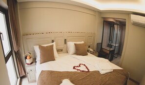 A hotel room with a large bed, a bedside table with a lamp, a chair, and an air conditioning unit. - X-Nellyi Boutique Hotel (Istanbul)