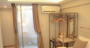A hotel room with a bed, a bedside table, a mirror, a wardrobe, and an air conditioning unit. - X-Nellyi Boutique Hotel (Istanbul)
