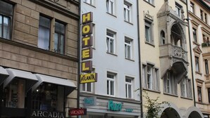 Un hôtel avec une enseigne indiquant « HÔTEL ATLANTA » et une devanture de magasin portant le nom « Run ».
