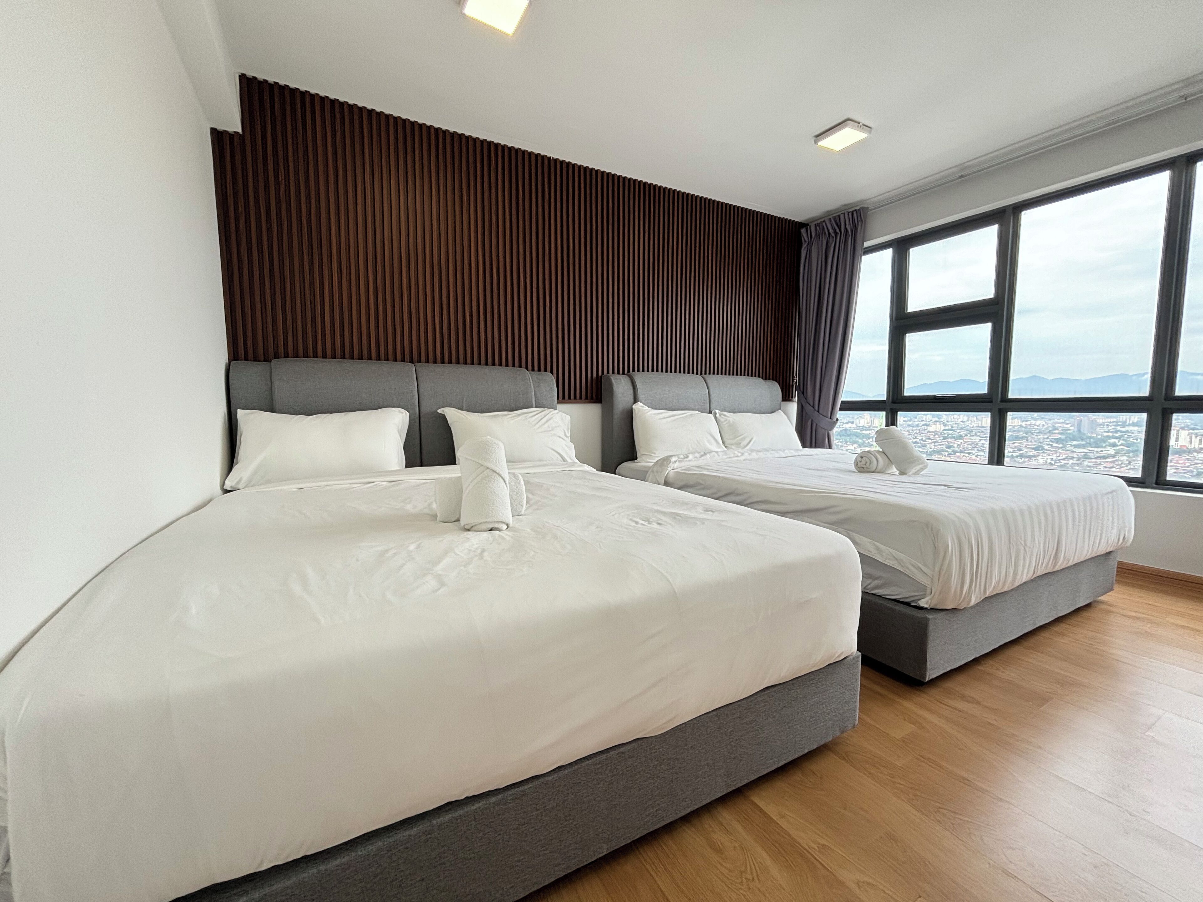 Habitación de hotel con dos camas, vistas a la ciudad y diseño moderno.