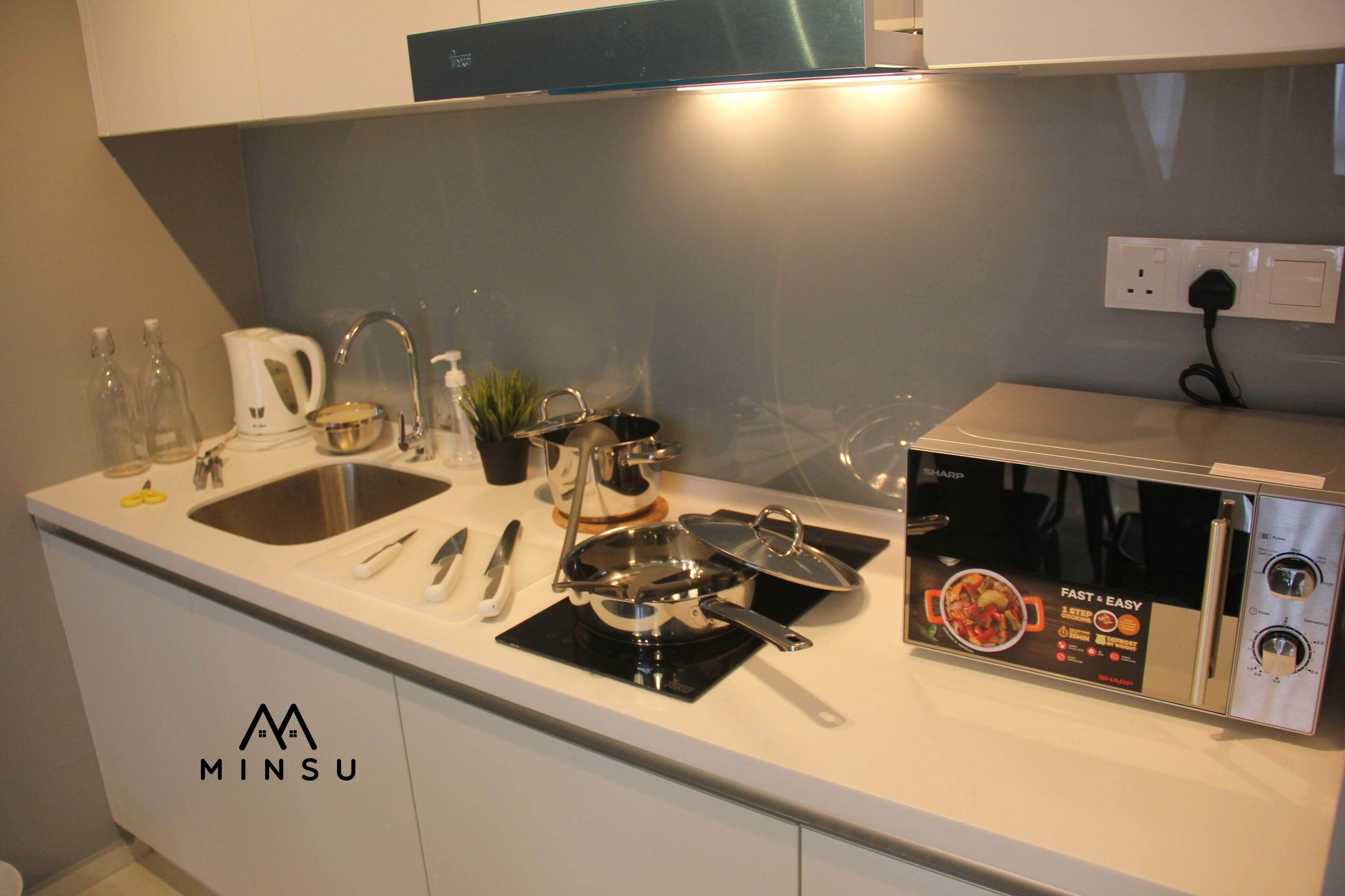 A modern kitchen with a built-in stove, sink, and a countertop with various kitchen items.