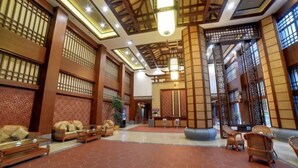 Spaziosa hall con arredi in legno tradizionale, pavimento piastrellato e pannelli decorativi.