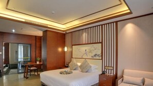 Una camera d'albergo moderna con un letto grande, una scrivania, un divano e un tavolo da pranzo.