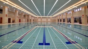 Un'ampia piscina interna con pavimento piastrellato e una corsia divisoria centrale.