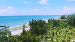 A coastal view with a beach, dense greenery, and a clear sky. - Timurbay by Seascape (Kuantan)