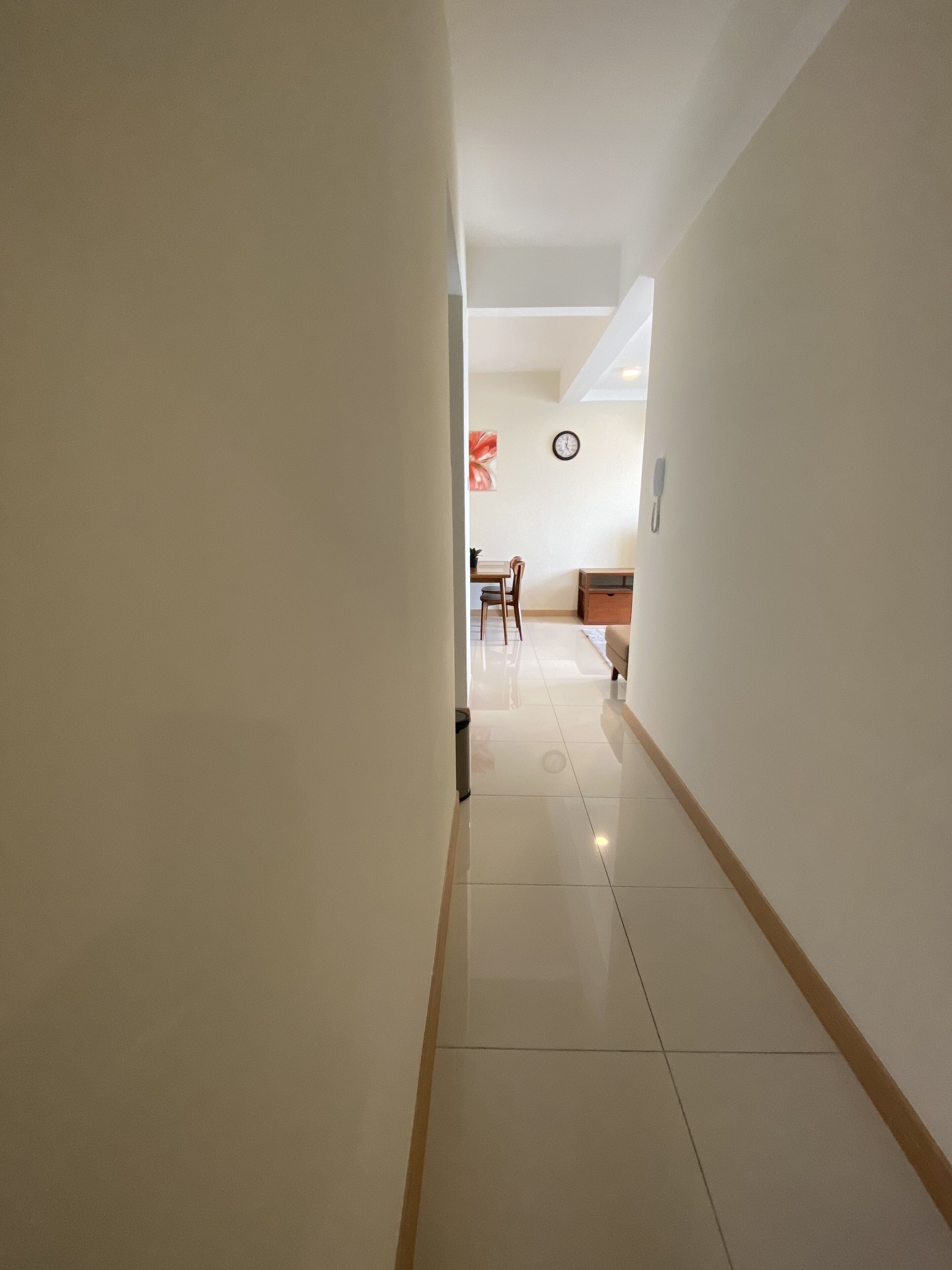 Un pasillo con comedor al final, con una mesa y sillas.