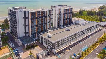 Un hotel moderno con varios edificios altos, un estacionamiento y vistas a la playa.