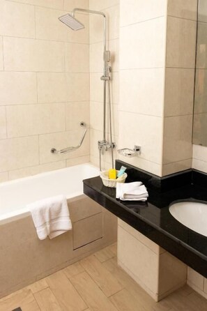 A modern bathroom with a bathtub, a shower, and a sink. - Sainte Famille Hotel (Kigali)