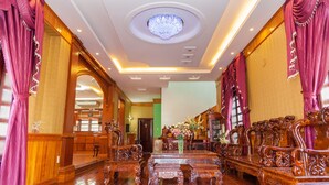 A luxurious room with ornate wooden furniture, a chandelier, and a large mirror. - Villa Binh Minh (Ho Chi Minh City)