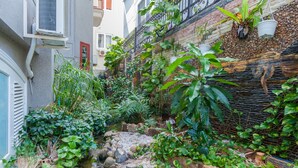 A narrow alley with a small stream, surrounded by lush greenery and plants. - Villa Binh Minh (Ho Chi Minh City)
