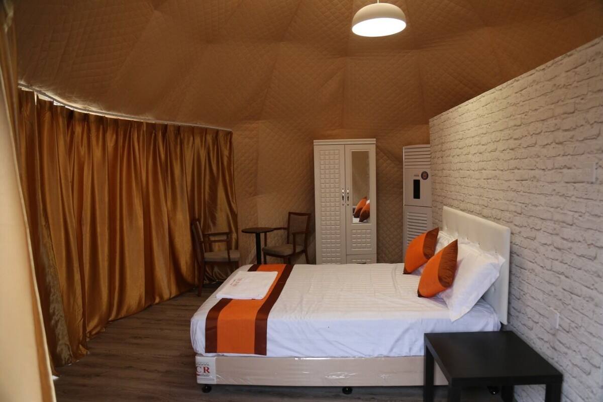 Ein Hotelzimmer mit Bett, Kleiderschrank, Schreibtisch und Stuhl.