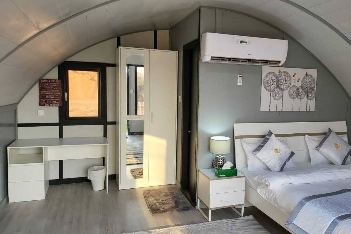 Ein Schlafzimmer mit Bett, Nachttisch und Schreibtisch.