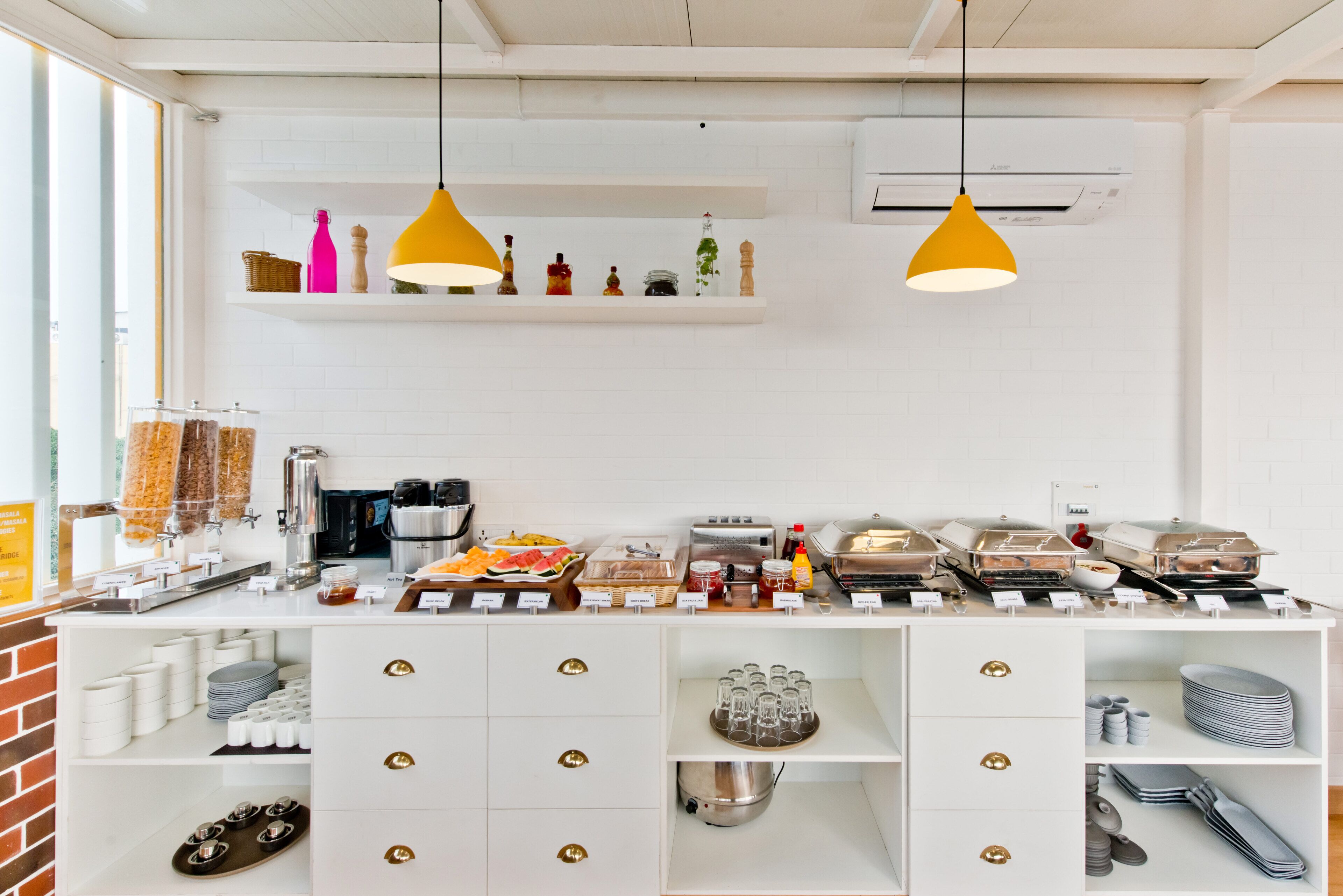 A breakfast bar with various food items, utensils, and storage drawers.