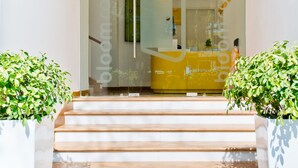 A modern entrance with a glass door leading to a reception area. - Bloomrooms @ City Centre (Bengaluru)